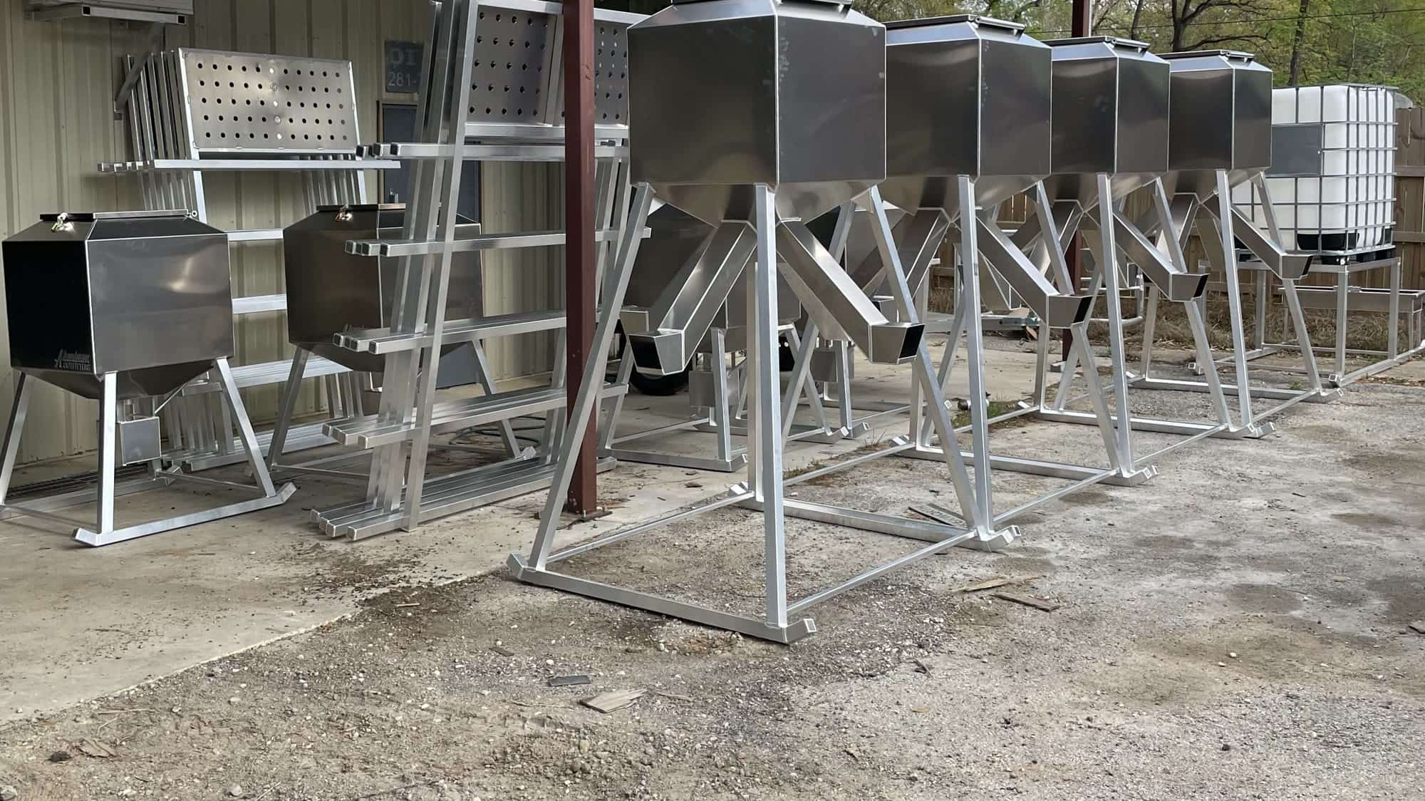 A row of Aluminum Outfitters feeders under the carport at the New Caney shop.