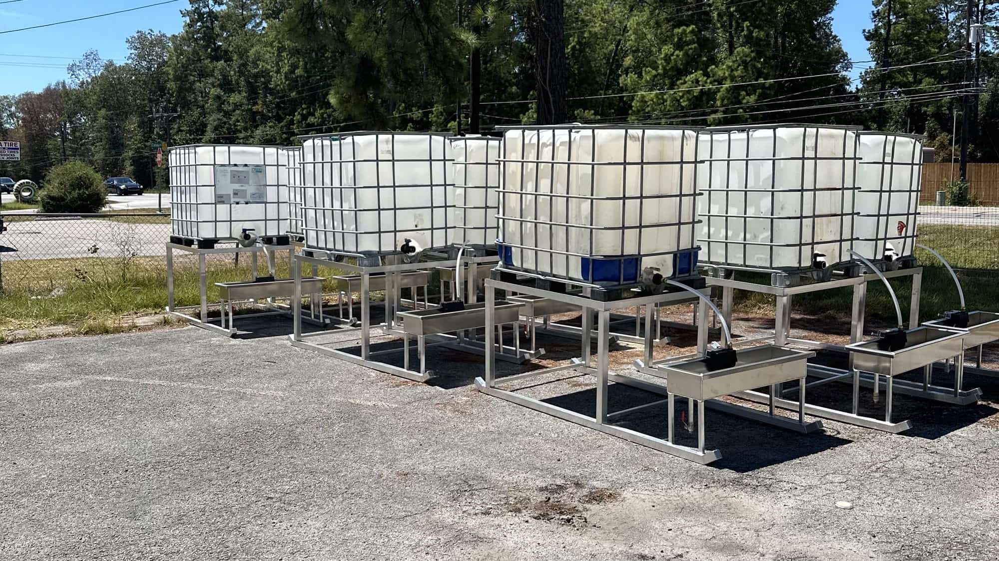 A row of aluminum water troughs in the yard at 19363 FM 1485.