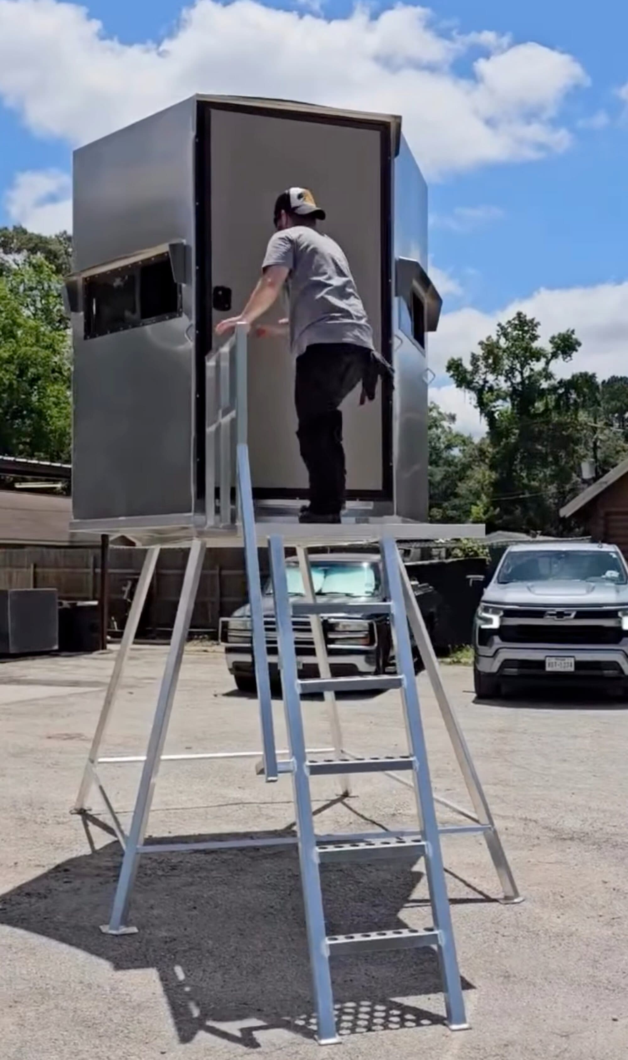 Aluminum deer blind mounted on a 6-foot platform with ladder and handrail, door open, at the New Caney shop.